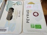 deux cartons de vin posés sur une table, avec une bouteille de vin à l'arrière-plan