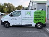 the van is parked on the side of the road in front of a building