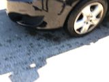 a black car with graffiti on the side of the road
