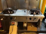 une cuisine équipée d'une cuisinière, d'un évier et d'une fenêtre