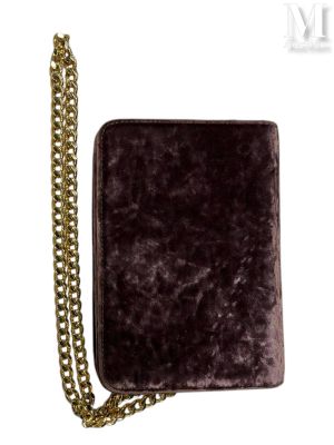 portefeuille en velours violet avec une chaîne dorée, sur fond blanc