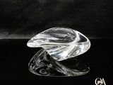 une image représentant une sculpture en verre représentant une feuille posée sur une surface noire