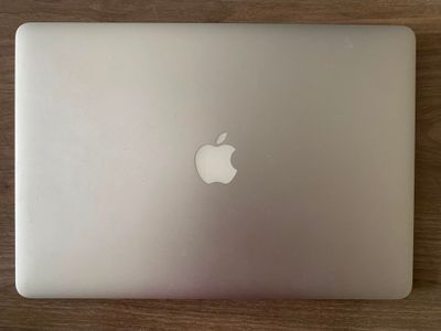 un ordinateur portable MacBook Pro d'Apple posé sur une table en bois