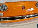 an orange car that is sitting on a white surface