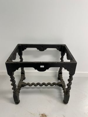 an old black table with a glass top on a white floor