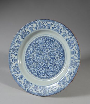 assiette bleue et blanche ornée d'un motif floral sur le bord