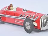 une petite voiture rouge avec un homme au volant