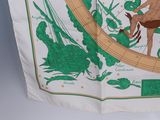 a white and green scarf with a picture of a man riding a horse