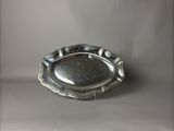 une photo d'une assiette en argent posée sur une table, sur fond blanc