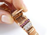 a person holding a watch that has diamonds and rubies on it