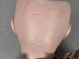 a close up of a doll ' s head with numbers on it