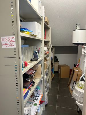 une pièce avec de nombreuses étagères et des cartons posés sur ces étagères
