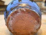 a close up of a blue and brown vase on a table