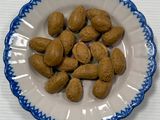 une assiette d'amandes posée sur une table blanche