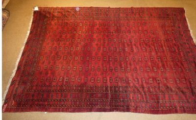 un tapis rouge posé à même le sol, sur fond marron
