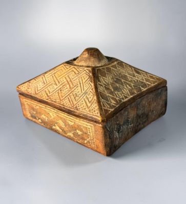 an old wooden box sitting on top of a white surface