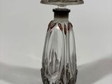 a small glass bottle with a lid on a white surface