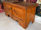 un vieux coffre en bois surmonté d'un miroir