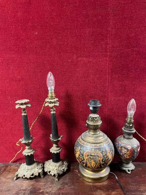 three antique lamps on a wooden table with a red wall in the background