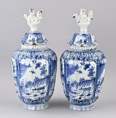 une paire de vases bleus et blancs décorés de personnages