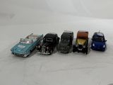 several toy cars are lined up in a row on a white surface