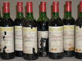six bouteilles de vin sont alignées sur une table