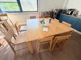 une table et des chaises en bois dans une pièce dotée d'une grande fenêtre