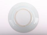 a white plate with a brown rim on a white table
