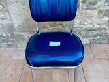 a blue chair that is sitting on a tile floor