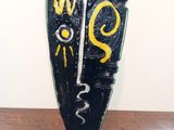 a black vase with a yellow and white design on it