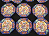 six blue and orange plates with designs on them on a black surface