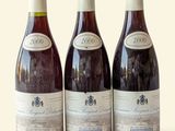 three bottles of wine sitting on top of a table next to each other