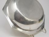 silver plate with a domed lid on a stand on a white surface