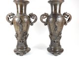 two vases that are sitting side by side on a white surface