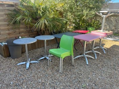 trois chaises et une table sur une surface recouverte de gravier