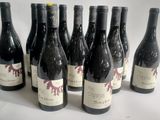 six bottles of wine are lined up in a row on a white surface