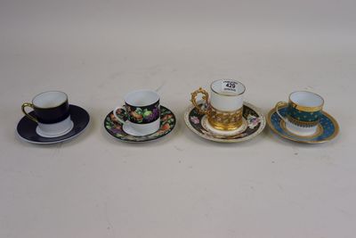 four cups and saucers are lined up on a white surface