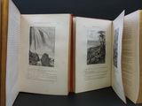three open books with pictures of mountains and waterfalls on them