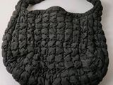an image of a black purse on a white surface