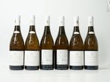six bouteilles de vin sont alignées sur une table