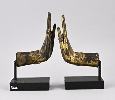 une paire de mains en bronze posées sur un socle noir