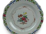 a plate with a floral design on it on a white surface