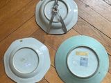 three plates sitting on a wooden floor next to each other