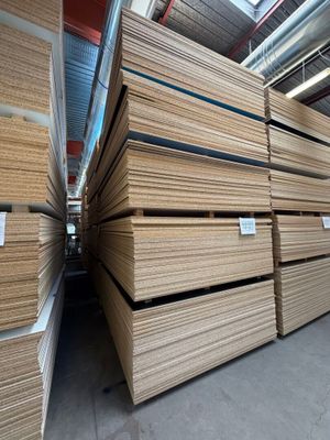 plusieurs piles de panneaux de contreplaqué empilés les uns sur les autres dans un entrepôt