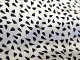 a close up of a black and white fabric with hearts on it