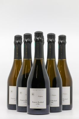 quatre bouteilles de vin sont alignées sur une surface blanche
