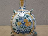 a blue and yellow vase sitting on a table