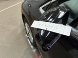 a sticker on the door handle of a car that is parked on the side of the road