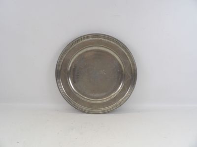 une plaque d'argent sur une surface blanche avec un fond blanc