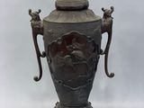 an image of a large bronze vase with two handles on a stand